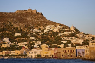 Panteli Fortress, Greek coastal village against a backdrop of hills at sunset, with traditional