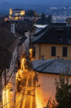 Illuminated alley with view of Isola San Giulio, Orta San Giulio, on Lake Orta, Province of Novara,