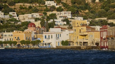 Colourful coastal houses with church in the background, located directly on the water, Agia Marina,