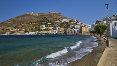 Panteli Fortress, seafront promenade of a coastal town with waves and beautiful hills, Agia Marina,