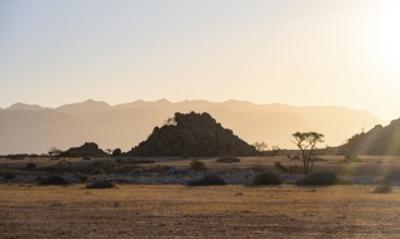 Desert landscape in the evening light at sunset, barren landscape with hills of stacked rocks,
