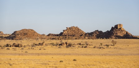 Barren landscape with hills of stacked rocks, desert landscape in the evening light at sunset,