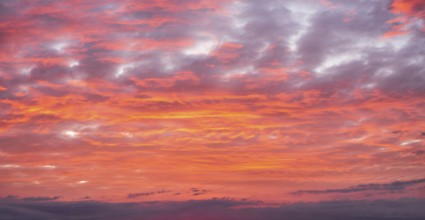 Background image for sky replacement, evening sky with illuminated red clouds at dusk after sunset