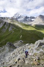 Mountaineer on hiking trail, Glorerhütte mountain hut and mountain peak in the background, Wiener