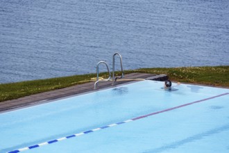 View from above of swimming pool by the sea, thermal bath, heated outdoor pool in Hofsos at the