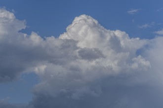 Dark storm clouds gather in the sky over a vast rural landscape, signalling an impending summer