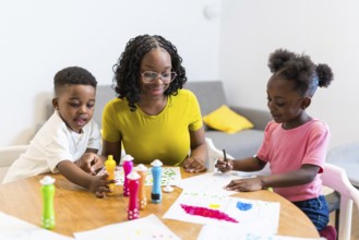 Mother and children enjoying creative playtime, using dot markers to create colorful artwork on