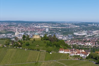 Vineyards and a hilltop building in front of a detailed city panorama, view of Rotenberg near