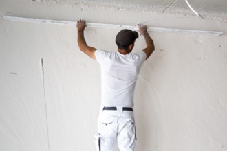 Plasterer smoothing and levelling interior walls