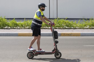 Man with electric scooter, Abu Dhabi, United Arab Emirates