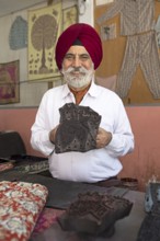 Indian Sikh, 68 years old, showing a wooden panel for woodblock printing, Jaipur, Rajasthan, India