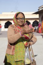 Indian woman holding a tea light at the Govind Dev Ji Hindu temple in the old city, Jaipur,