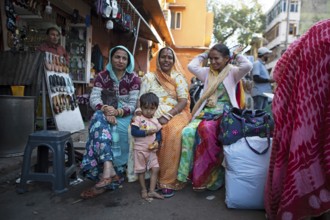 Indian child and Indian woman in colourful saris laughing out of focus in the old town, Jaipur,