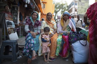 Indian woman in colourful saris and a child in the old town, Jaipur, Rajasthan, India