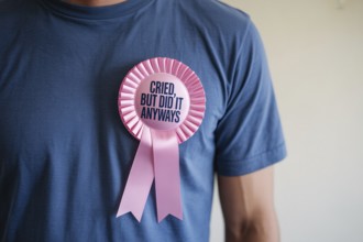 Satirical rosette on men's shirt with text cried, but I did it anyways. Irony of