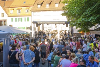 A large crowd gathers around a stage during a concert at a town festival, 950 years Weil der Stadt