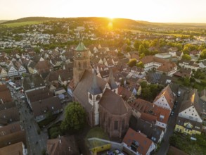 Aerial view of a church surrounded by an idyllic cityscape at sunset, 950 years Weil der Stadt