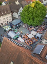 Viewed from above: well-attended festival site with tables and trees in the town centre, 950th