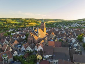A picturesque village with a church under warm evening light in a hilly landscape, 950 years Weil