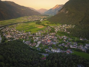 Panoramic view of a town in a valley surrounded by mountains at night