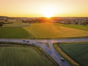 Fields and streets under a golden sunset, quiet evening atmosphere with traffic, Renningen, Germany