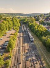 Top view of trains and tracks amidst trees and a residential area, summer, Weil der Stadt railway