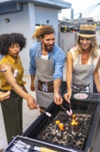 Cheerful friends enjoying a rooftop party, grilling marshmallows on skewers over a lively barbecue