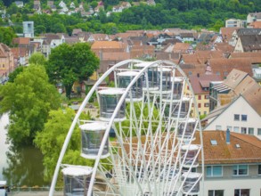 Ferris wheel in front of a town with hills and river in the background, Ferris wheel construction,