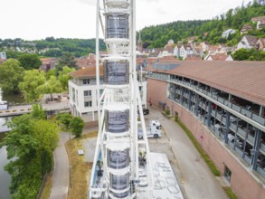 Narrow street view next to a high Ferris wheel in an urban environment, construction of a Ferris