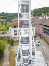 Ferris wheel set up right next to modern buildings in the town centre, Ferris wheel construction,