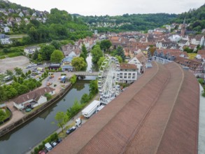 Aerial view of a town with a Ferris wheel in the centre, surrounded by densely built-up houses and