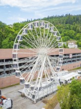 Large Ferris wheel in front of wooded hills and buildings, construction of Ferris wheel, Calw,