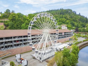 White Ferris wheel in front of wooded hills and blue sky, construction of Ferris wheel, Calw, Black