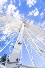 Close-up of a Ferris wheel with blue sky and clouds, Ferris wheel construction for the 950th