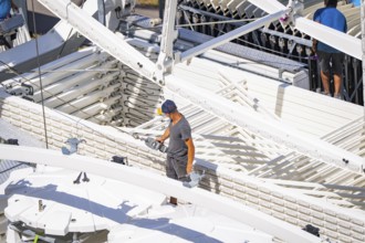 Person standing between technical structures while a Ferris wheel is being erected, Ferris wheel