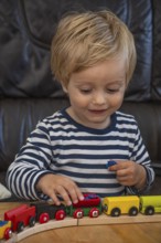 Blond boy, 2 years old, playing with toy train in Ystad, Skåne County, Sweden, Scandinavia