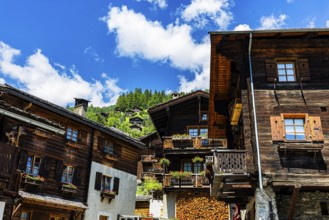 Old wooden houses in log construction, decorated with flowers, historic village centre, Grimentz,