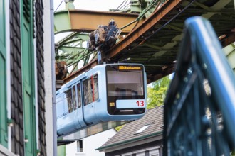 The Wuppertal suspension railway runs through Vohwinkel in front of buildings from the Wilhelminian