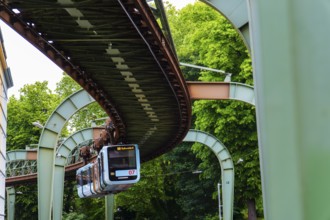 The Wuppertal suspension railway runs through Vohwinkel in front of buildings from the Wilhelminian