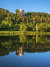 Prunn Castle on a steep cliff above the Altmühl Valley in the evening light, reflection in the