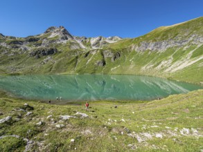 Hiker at lake Engeratsgundsee, mountain range between Oberstdorf and Bad Hindelang, Allgaeu,