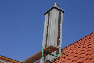 Chimney with high-quality titanium zinc cladding on a straight tiled roof
