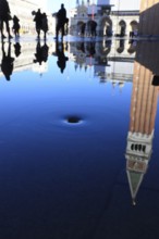Reflection of the Campanile with water vortex of the flowing flood water, Acqua alta, Venice,