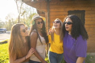 Four diverse female friends laughing and bonding under the warm sun, enjoying a carefree day