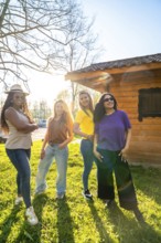 Four diverse female friends enjoying a sunny day together, posing confidently in front of a