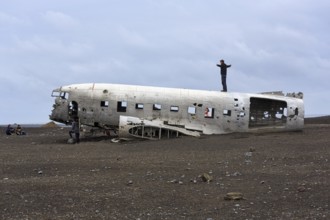 Tourist on aircraft wreckage, US Navy Douglas DC-3 transport plane, Sander, volcanic landscape,
