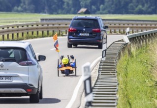Man with handbike travelling on a country road. Special bike with manual drive for disabled people.