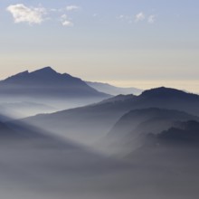 Mountain silhouettes... Alpine peaks and mountain ranges in the Bavarian Alps, light fog rises from