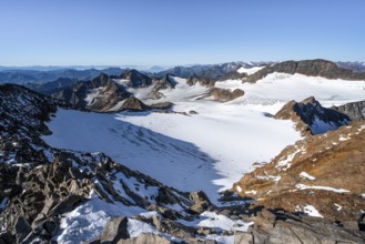 Narrow rocky ridge at the Wilder Freiger summit, picturesque high mountain landscape with snow,