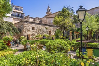 Lush green ornamental garden with visitors at the Arab Baths a historic site in city of Palma a